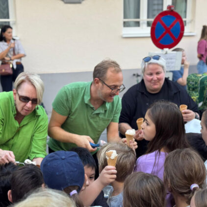Yvonne, Fabian und Barbara verteilen Eis an die Kinder